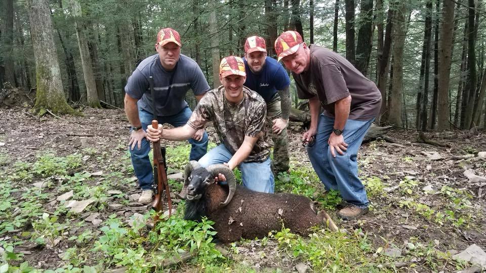 Group of hunters posing with Black Hawaiian Ram kill