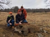 Family of hunters posing with boar kill