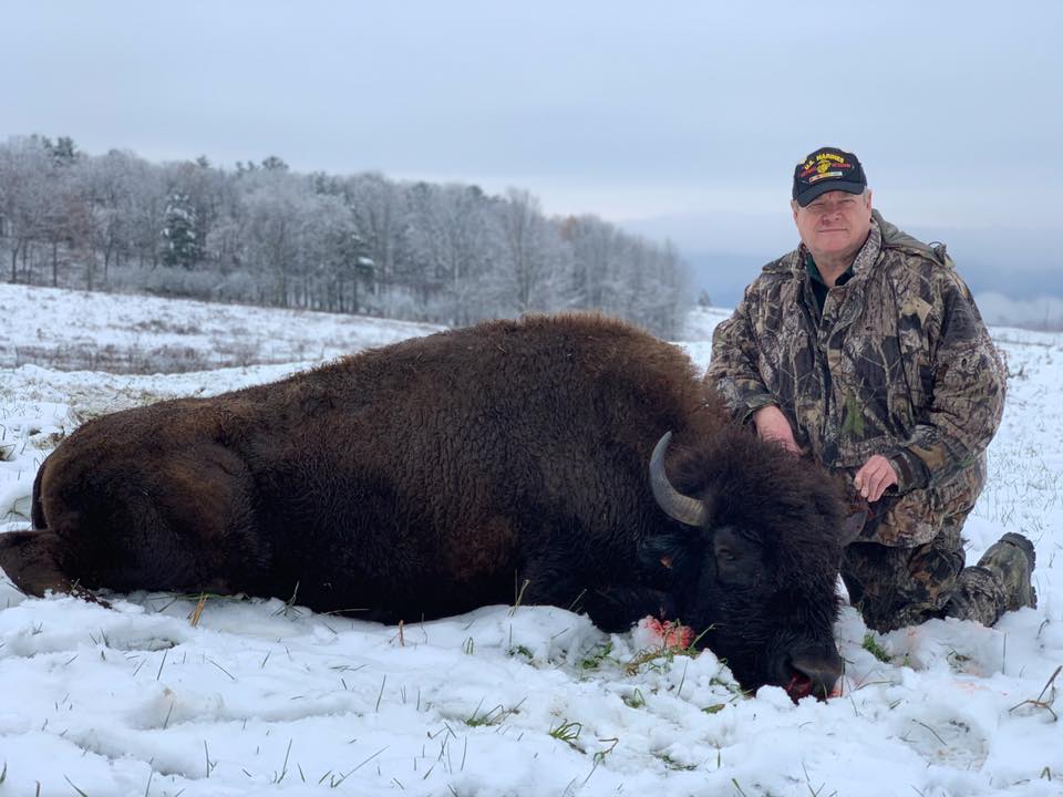 Hunter posing with bison kill