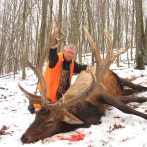 Hunter posing with elk kill and crossbow