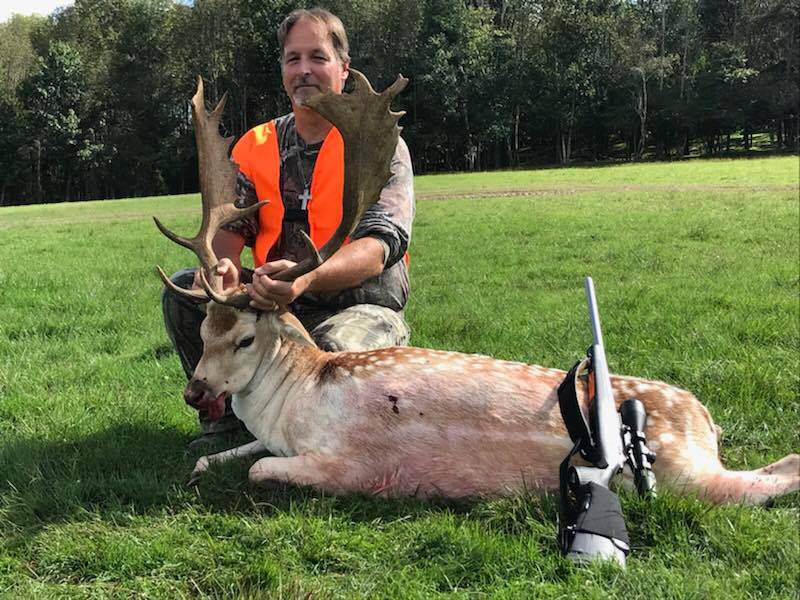 Man posing with hunted fallow deer