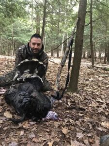Hunter displaying his turkey kill next to crossbow
