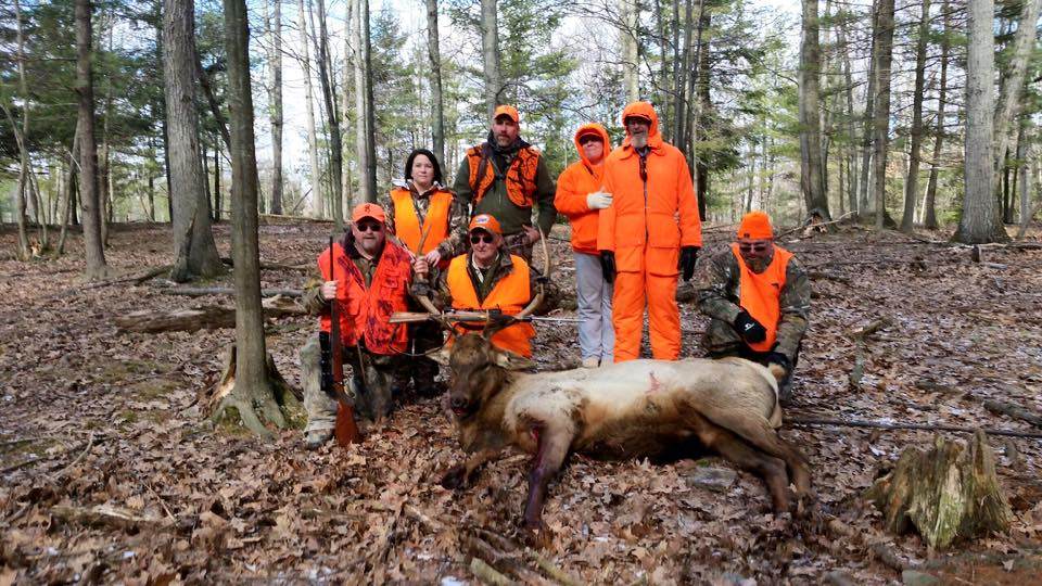 Group of Hunters around Trophy Elk