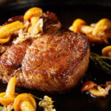 Gourmet grilled wild venison steak with mushrooms, herbs and onion in a close up view