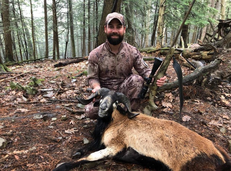Hunter posing with rifle and the Corsican ram he shot