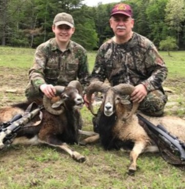 Father and son posing with a Corsican Ram