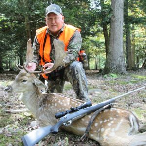 Man posing with hunted fallow deer