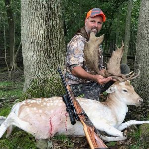Man posing with hunted fallow deer