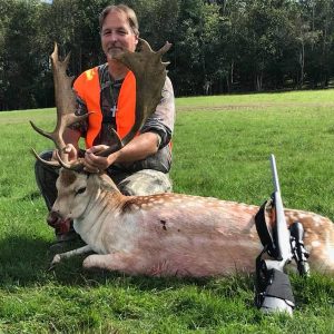 Man posing with hunted fallow deer