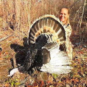 Man posing with hunted turkey