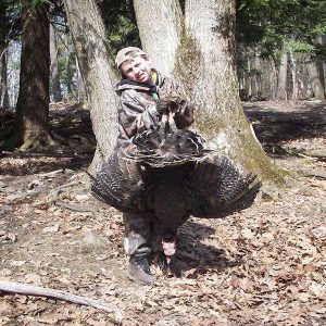 Man posing with hunted turkey