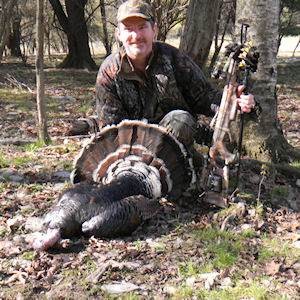 Man posing with hunted turkey