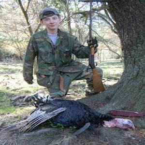 Teen posing with hunted turkey