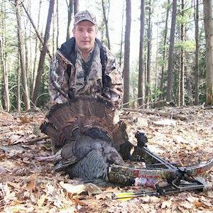 Man posing with hunted turkey