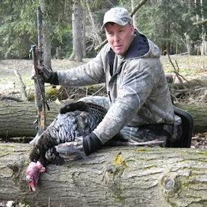 Man posing with hunted turkey