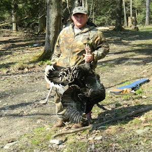Man posing with hunted turkey