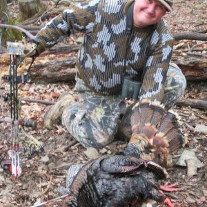 Man posing with hunted turkey